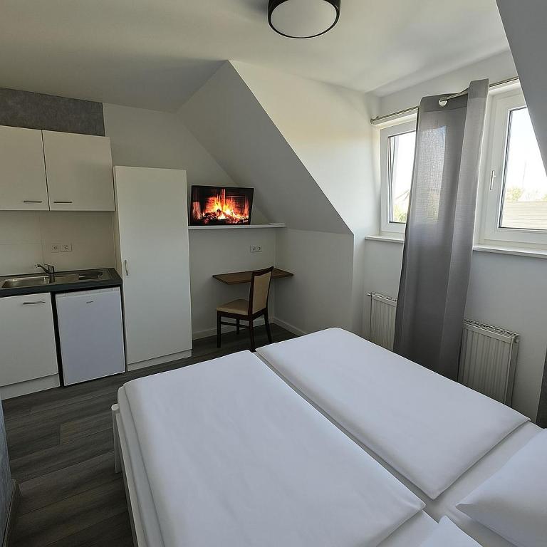 a bedroom with a bed and a kitchen with a fireplace at Ein zimmer Apartment in Dormagen