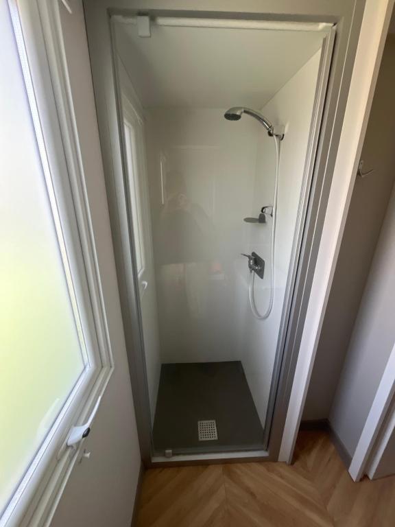 a shower with a glass door in a bathroom at Mobil-Home neuf Valras-Plage - Camping 4 étoiles les Sables du Midi in Valras-Plage