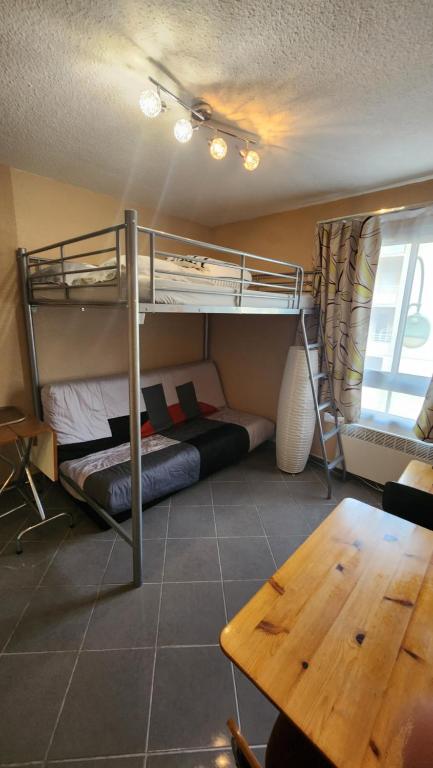 une chambre avec un lit superposé et une table dans l'établissement Studio Les logis de Paray, à Paray-le-Monial