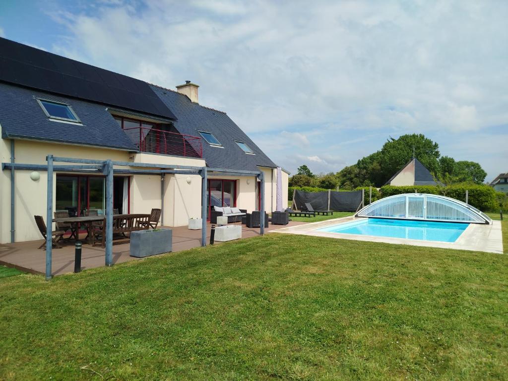 une maison avec une piscine dans la cour dans l'établissement Grande maison familiale, à Penmarcʼh