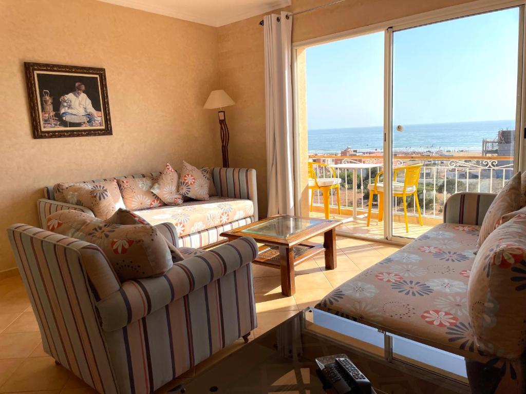 ein Wohnzimmer mit Sofa und Tisch in der Unterkunft A5 Bel Appartement vue mer a 300m de la plage in Agadir