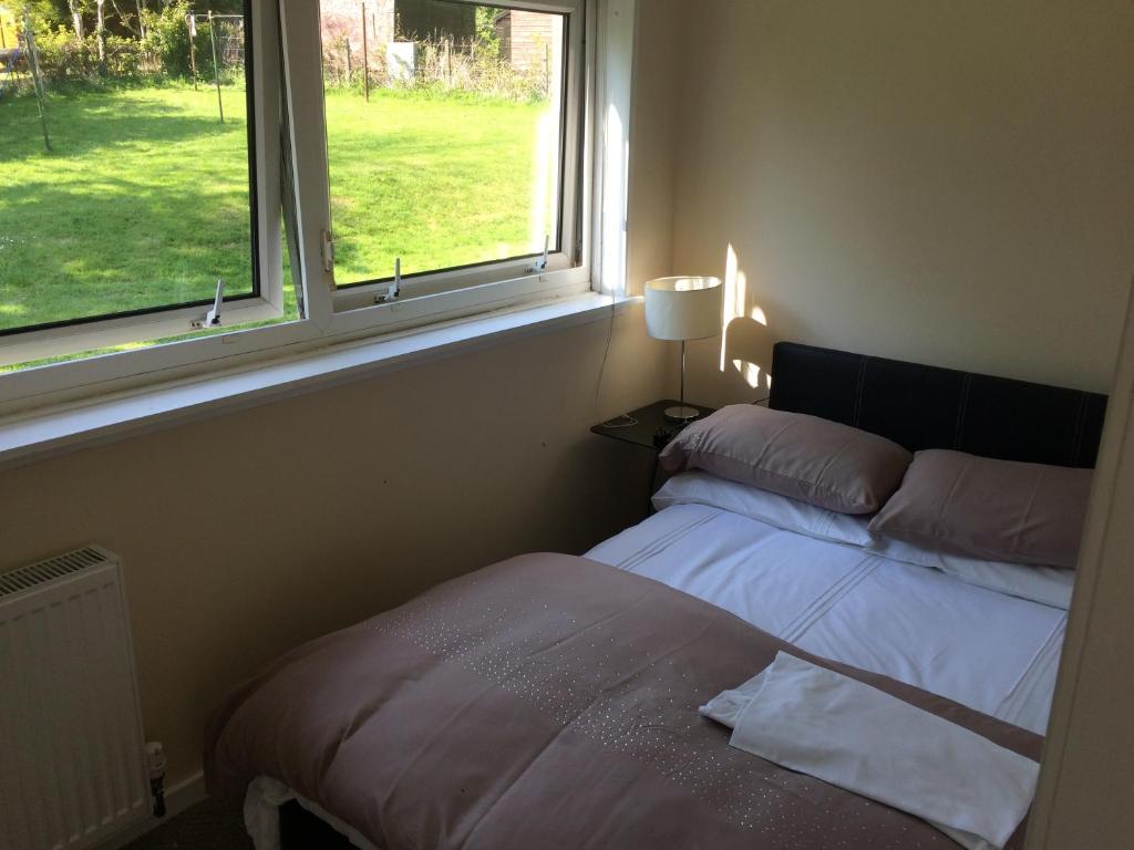 1 dormitorio con cama y ventana en Kilbarchan Flat, en Kilbarchan