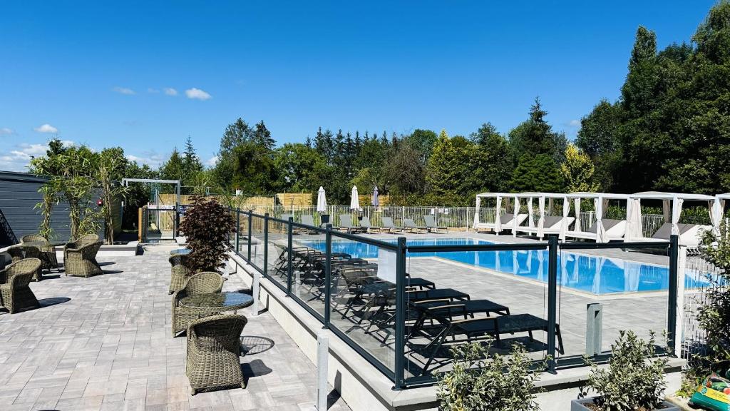 une piscine avec des chaises longues et une clôture dans l'établissement Domaine du parc, à Grandvillers