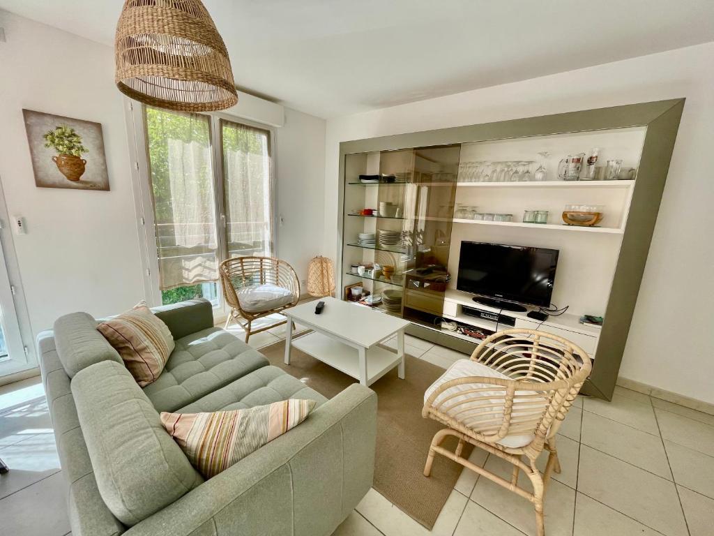 un salon avec un canapé, des chaises et une télévision dans l'établissement Beau Rivage, à Cavalaire-sur-Mer