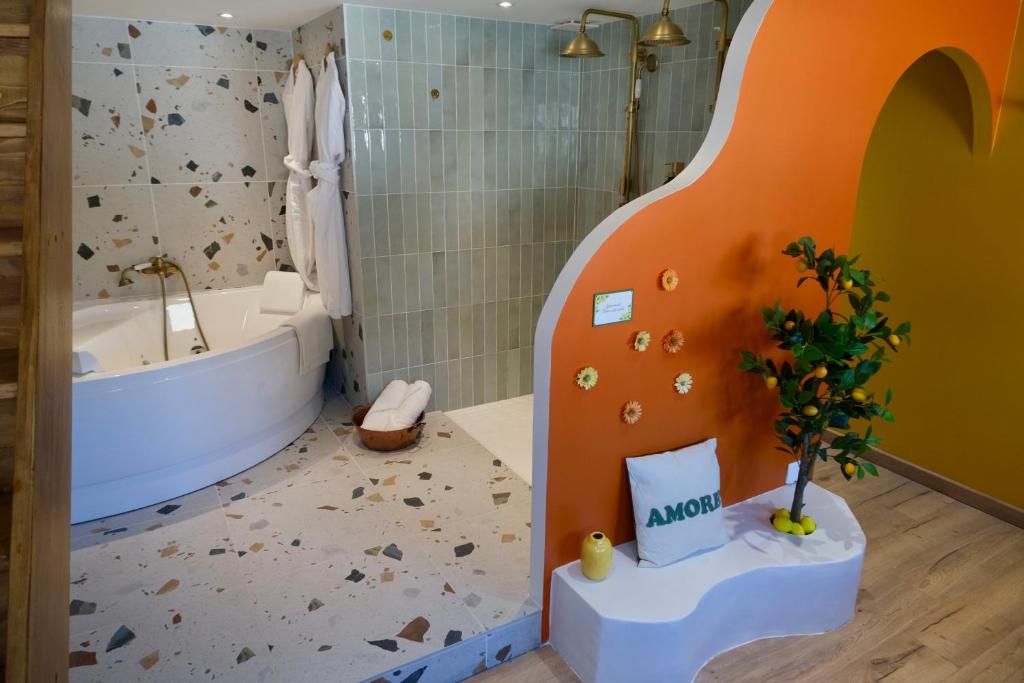un bagno con vasca e un albero di Dolcevita Suite - Signature italienne avec spa et filet a Saint-Étienne