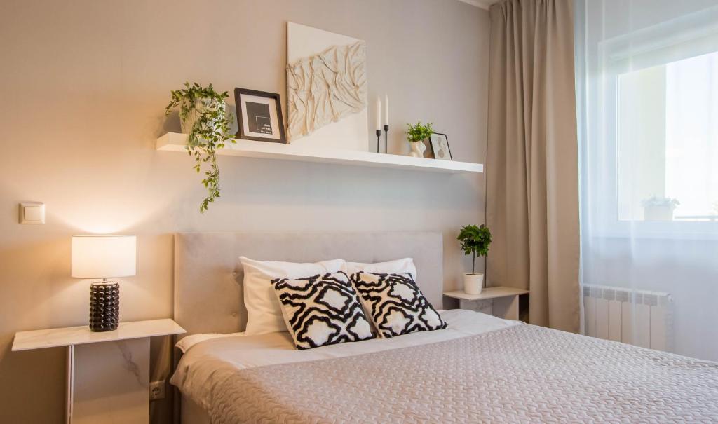 a bedroom with a bed with two tables and a window at Aardla Cozy Apartment in Tartu