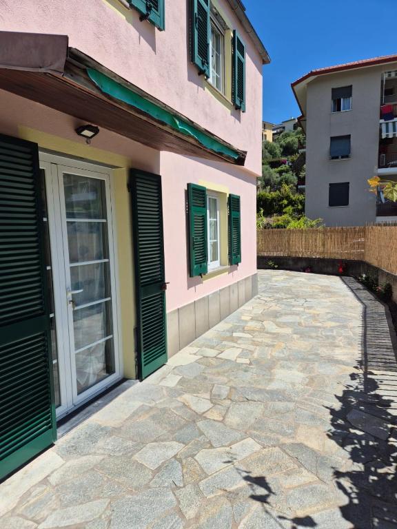 a house with green shutters and a stone driveway at Da Gio' e Eli in Sestri Levante