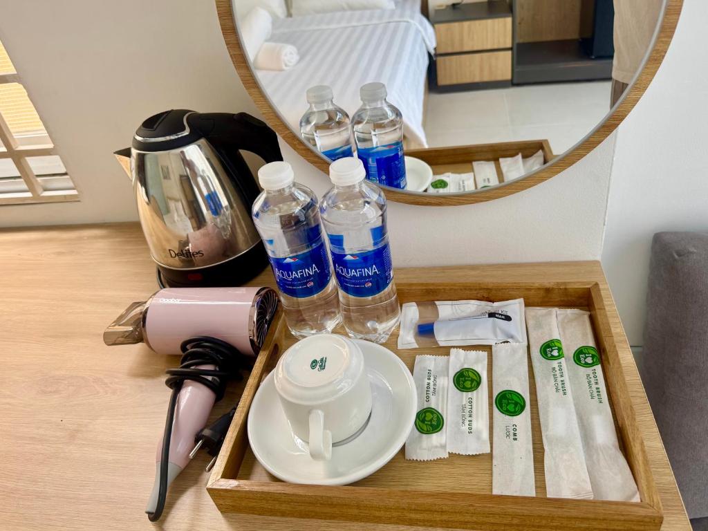 Una bandeja con botellas de agua y un plato sobre una mesa. en Atusy Boutique Hotel, en Ho Chi Minh