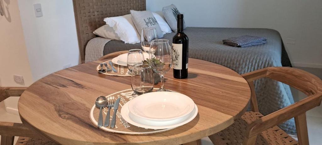 a wooden table with a bottle of wine and glasses at Metra DS Puerto Norte in Rosario
