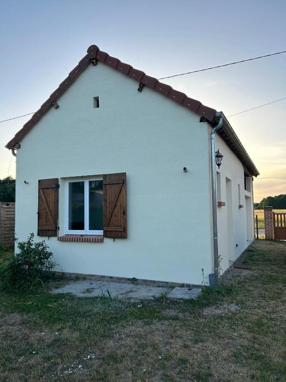 une maison blanche avec une fenêtre et des portes en bois dans l'établissement Logement : 2 chambres (5 couchages), salle de bain, à Pierrefitte-sur-Sauldre