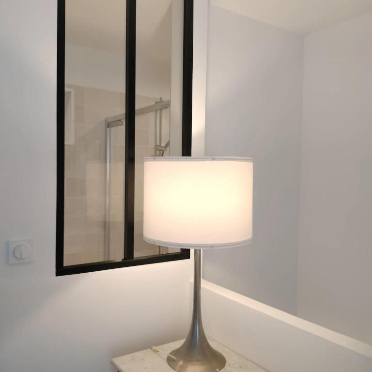 une lampe sur une table devant un miroir dans l'établissement BORD de MER au COEUR de la station Joli duplex contemporain équipé, à Bénodet