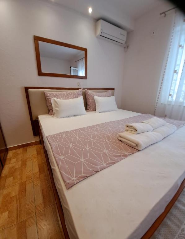 a large white bed in a room with a mirror at Pansion Ivana studios in Baška Voda
