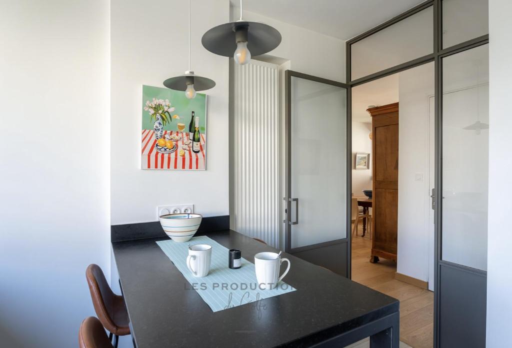 une salle à manger avec une table noire et un miroir dans l'établissement Vannes centre - 70m2 - 4 pers Emplacement IDEAL, à Vannes