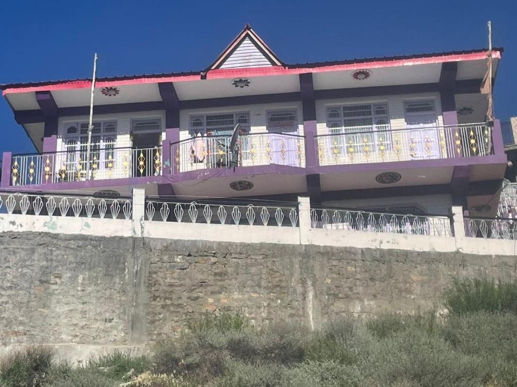 a house with a balcony on top of a wall at The hidden heaven homestay kalpa in Chini