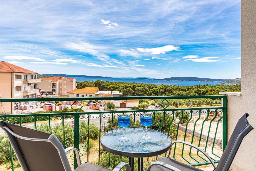 a balcony with a table and chairs and a view of the ocean at Olive Garden in Seget Vranjica