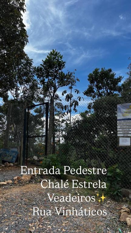 a sign in a park with trees in the background at Chales Estrela Veadeiros in Alto Paraíso de Goiás
