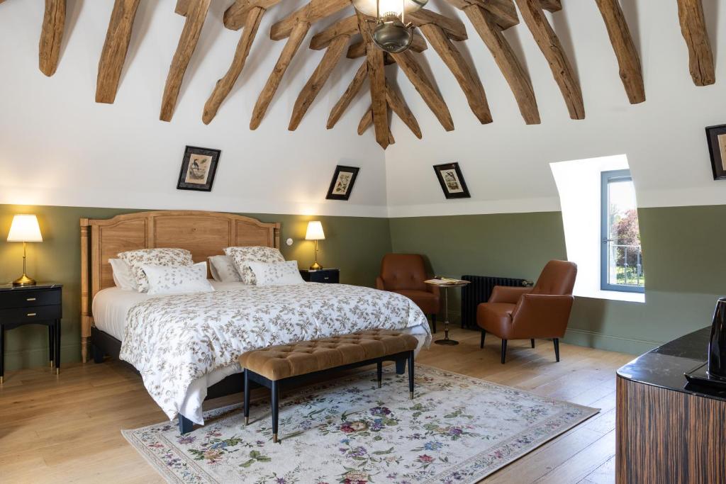een slaapkamer met een bed en een stoel bij Le Domaine de la Haye Chambres d'Hôtes in Saint-Christophe-du-Bois