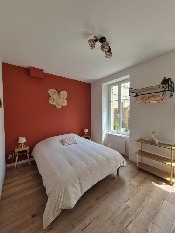 a bedroom with a large bed and a window at Charmant studio avec cour privée in Rochefort