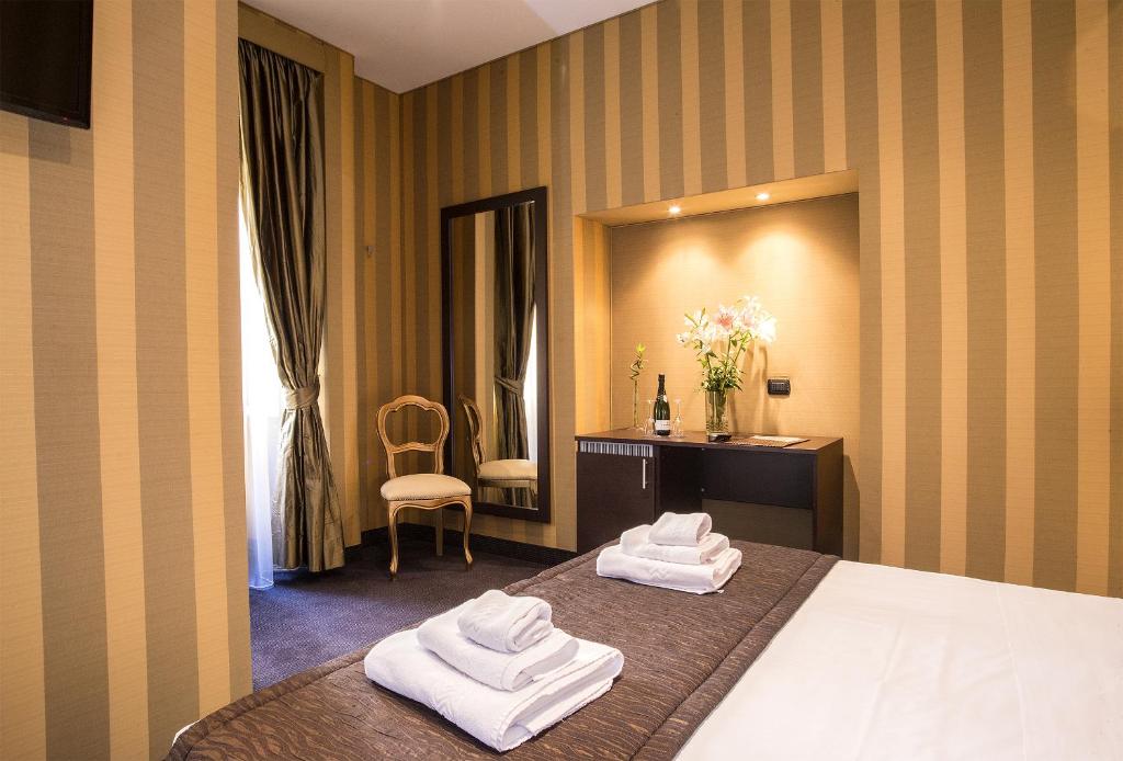 una camera d'albergo con due asciugamani su un letto di AS Planet a Roma