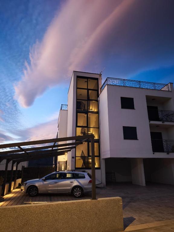 a car parked in front of a building at Apartments SORELLE in Podstrana