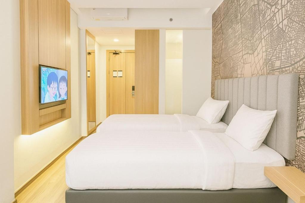 Postel nebo postele na pokoji v ubytování QNZ Hotel Jakarta