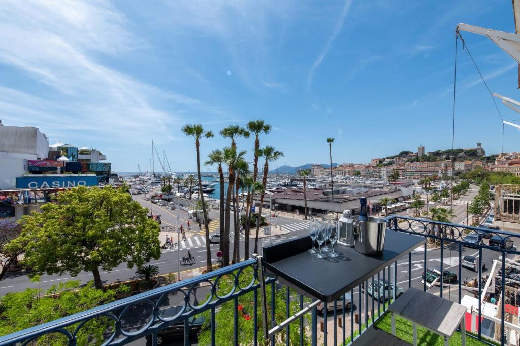 un balcon avec une table et une vue sur une ville dans l'établissement Prestige & Comfort Facing the Palais des Festivals, à Cannes