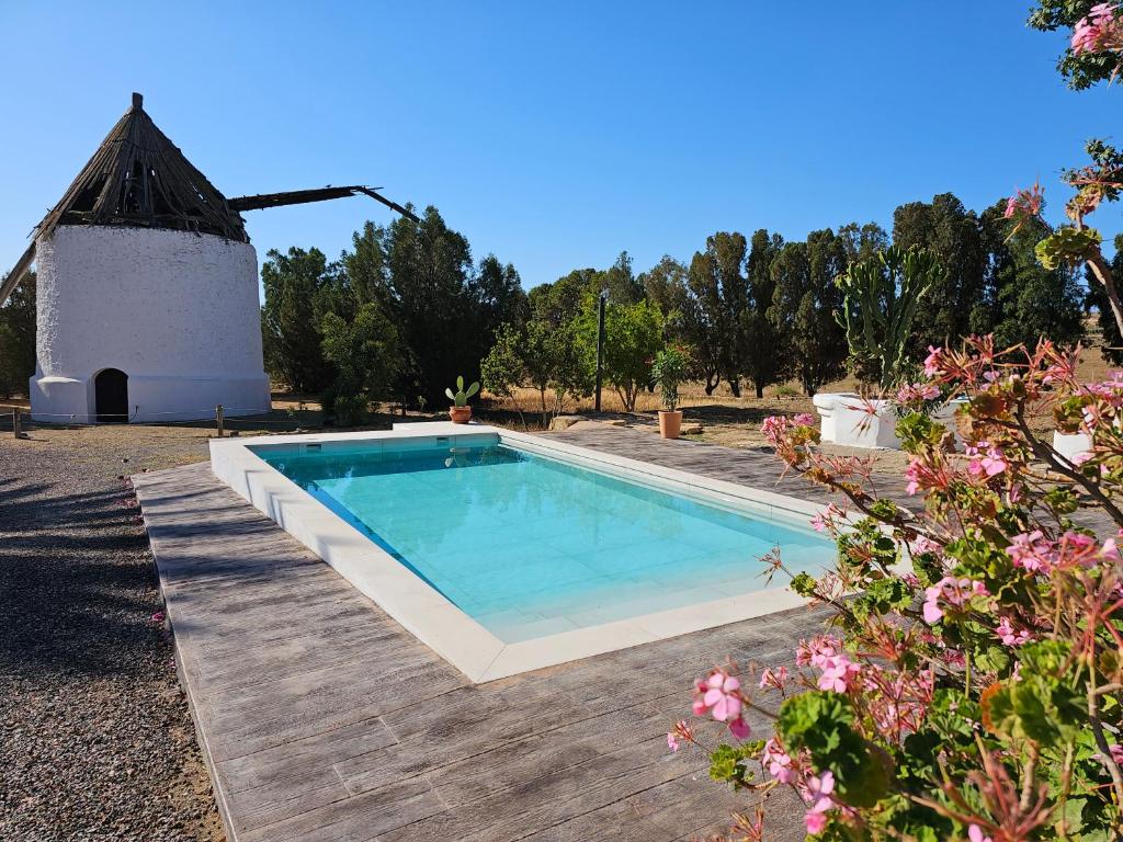 a swimming pool in a yard with a windmill at El Molino de arriba in Níjar