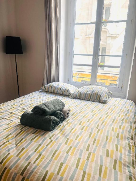 - un lit avec 2 oreillers et une fenêtre dans l'établissement Studio Champs Elysées Ponthieu, à Paris