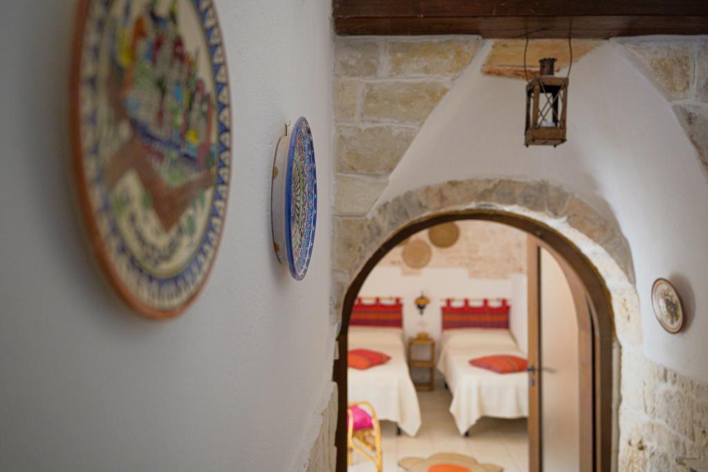 ein Torbogen in einem Haus mit einem Zimmer mit zwei Betten in der Unterkunft Villa dei Tigli - trulli e relax in Castellana Grotte