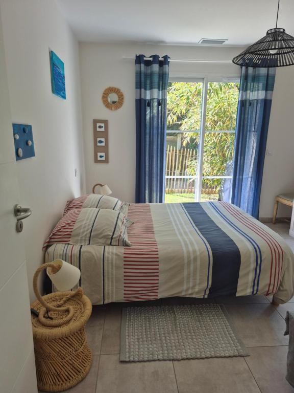 sypialnia z łóżkiem i oknem w obiekcie Maison Andernos Les Bains - Spa Jacuzzi et Piscine w mieście Andernos-les-Bains