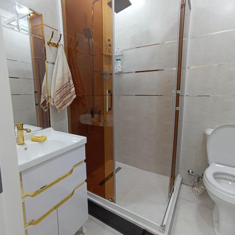 un bagno con doccia, lavandino e WC di Апартамент с 3 комнатами a Muruntau