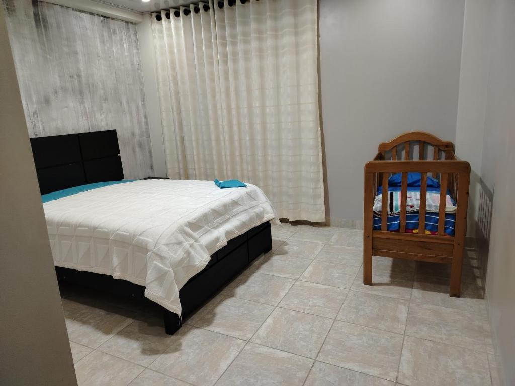 una camera con letto e culla in legno di Residencial MARCA a La Playa Bejarano