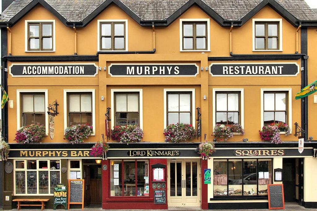 un grande edificio giallo con dei cartelli di Murphys of Killarney a Killarney