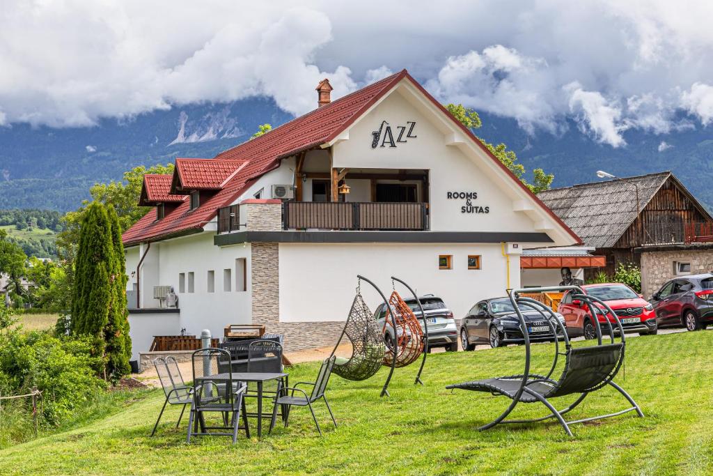 un grupo de sillas sentadas en el césped frente a una casa en Jazz Bled B&amp;B, en Bled