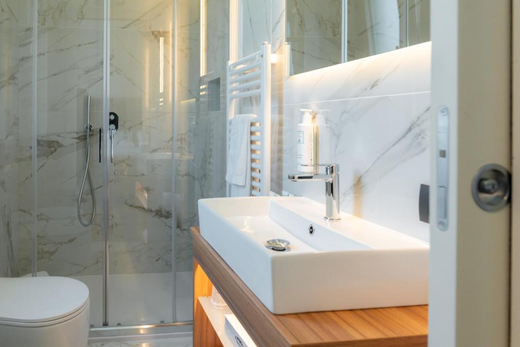 a white bathroom with a sink and a shower at Hotel Florida Lerici in Lerici