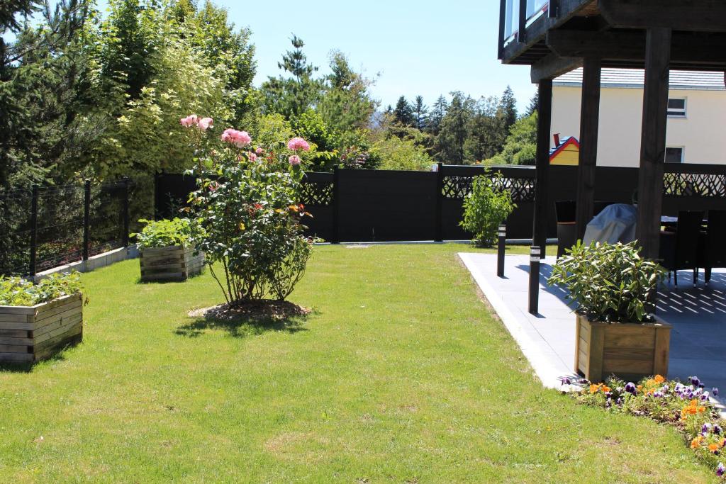 a garden with flowers in a yard next to a house at Gite chez Isabelle in Villers-le-Lac