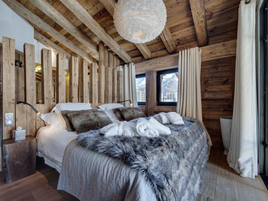 sypialnia z dużym łóżkiem w drewnianym domku w obiekcie Appartement de luxe avec jacuzzi, terrasse et cheminée - 10 personnes - FR-1-567-97 w mieście Val dʼIsère