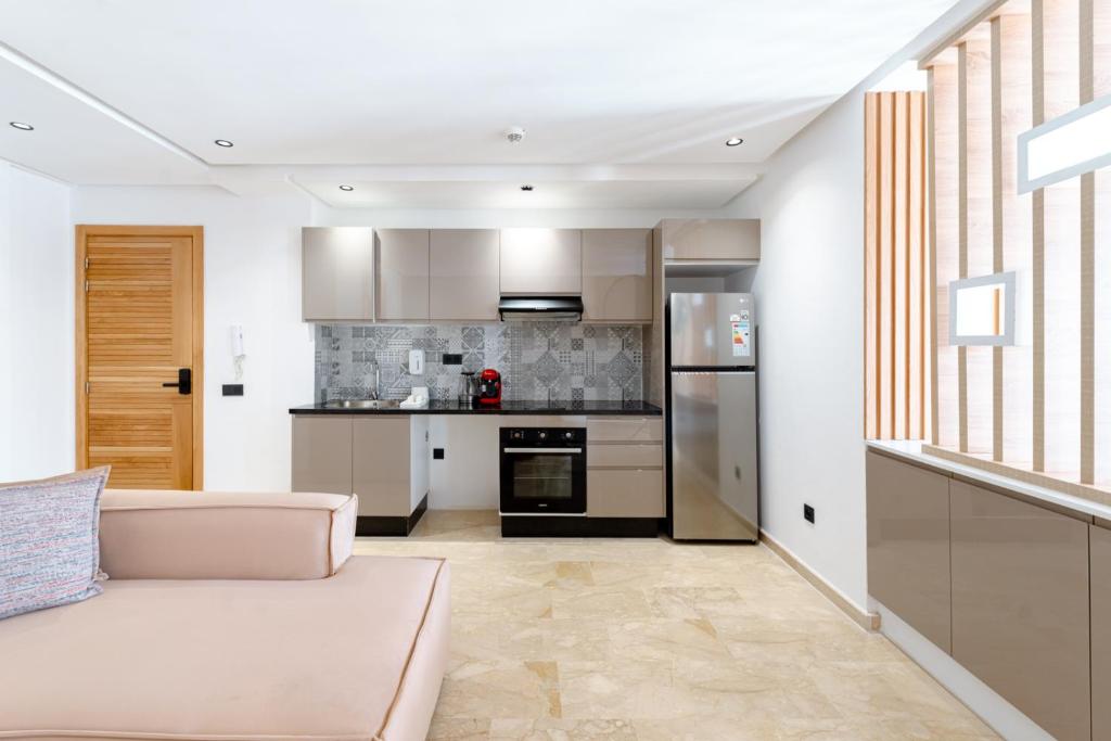 a living room with a couch and a kitchen at Spinoza House Appart Hôtel in Casablanca