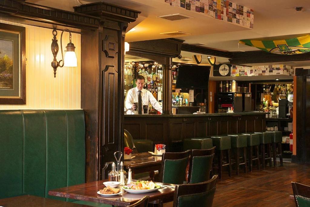 Un uomo in piedi in un bar in un ristorante di Murphys of Killarney a Killarney