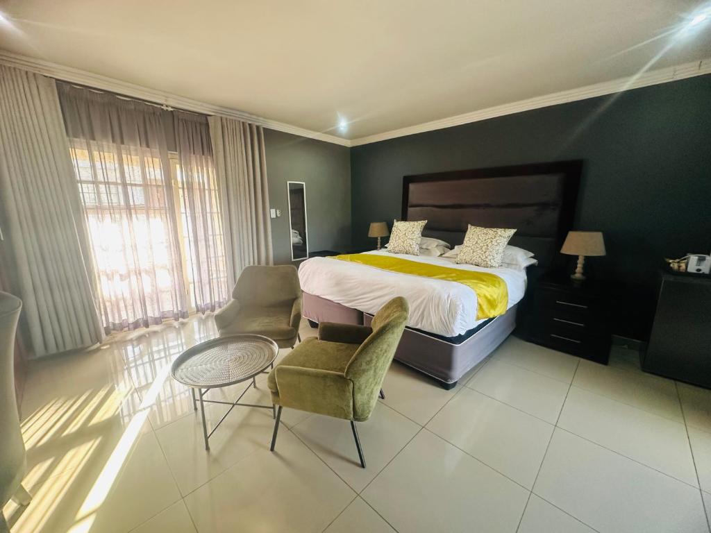 a bedroom with a bed and a table and chairs at 1 OAK Resort in Thohoyandou