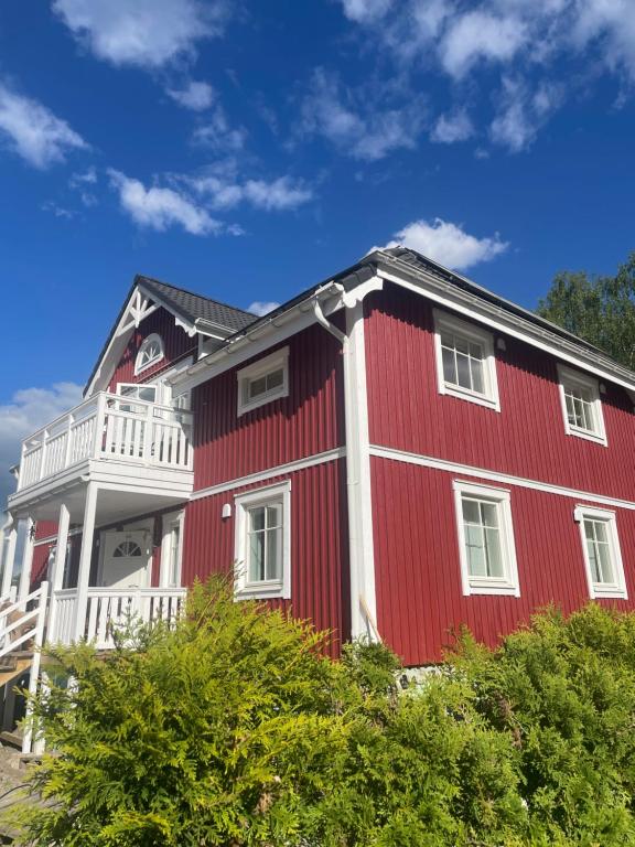 Casa roja y blanca con balcón blanco en Villa Småland-Edles Naturidyll bei Berlin, en Glienicke