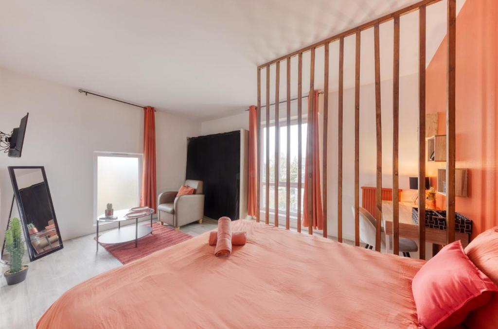 1 dormitorio con 1 cama grande con colcha rosa en Chambre orange 4, en Courcouronnes
