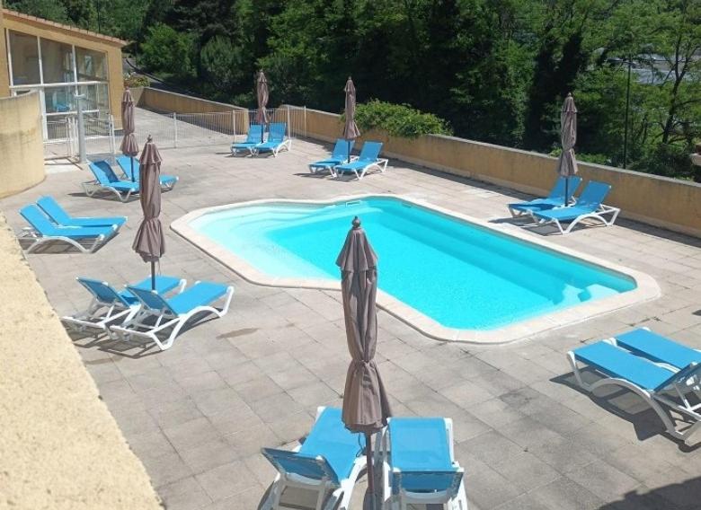 eine Gruppe von Stühlen und ein Swimmingpool in der Unterkunft Le Caldarium - Classé 2 Etoiles - Thermes 10 mn - 6 pers in Avène