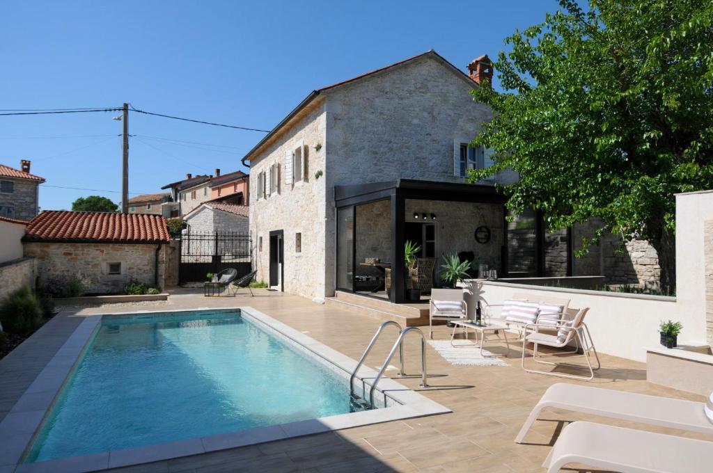 a swimming pool in the backyard of a house at Villa Angelina - design stone house in Markovac in Višnjan
