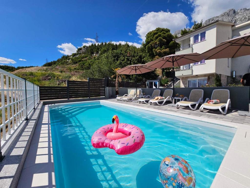 a swimming pool with a pink flamingo in the water at Apartment Tomic Makarska in Makarska