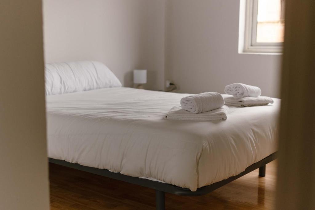 a bedroom with a bed with towels on it at Albaceteloft Avenida España in Albacete
