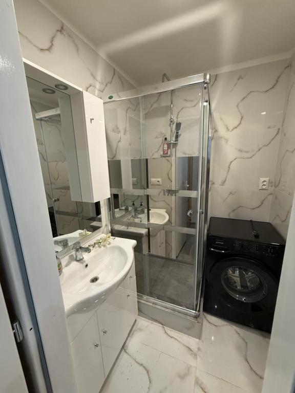 bagno con lavandino, doccia e lavatrice di Apartmán s veľkou terasou v srdci Trenčína a Trenčín