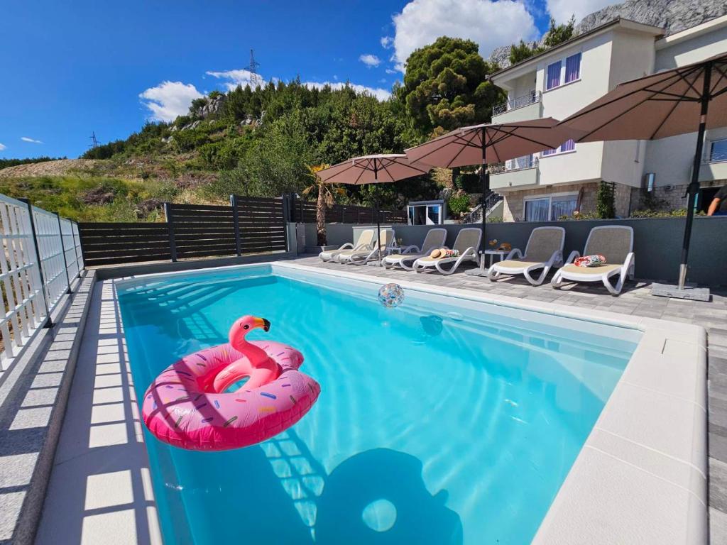 une piscine avec un flamingo rose dans l'eau dans l'établissement Apartment Tomic 2, à Makarska