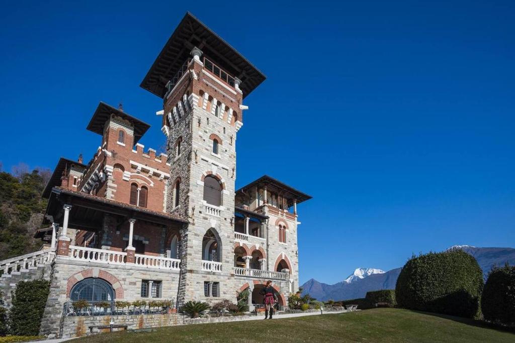 a building with a tower on top of a field at VILLA GAETA Penthouse in Nobiallo