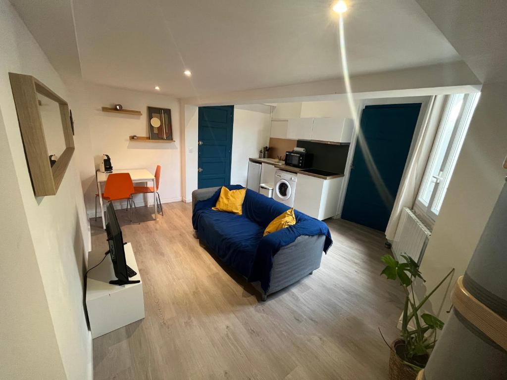 un salon avec un canapé bleu et une cuisine dans l'établissement Le perchoir de la préfecture, à Montpellier